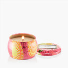 Pink floral-patterned candle in a tin with lid on a white background