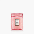 Pink candle with Voluspa label on a white background