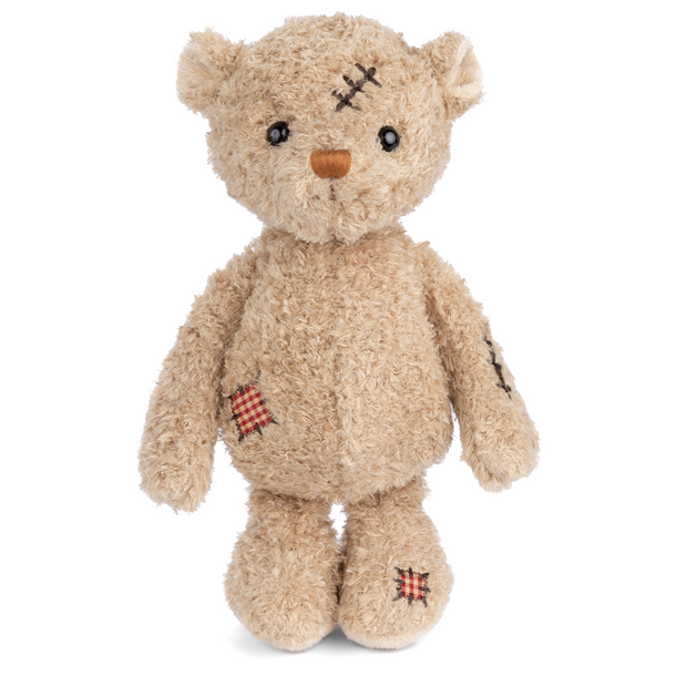 Stuffed teddy bear with bandages and stitches on a white background