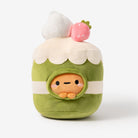 Plush toy resembling a character in a green outfit with white cream and pink cherry on top, on a white background.