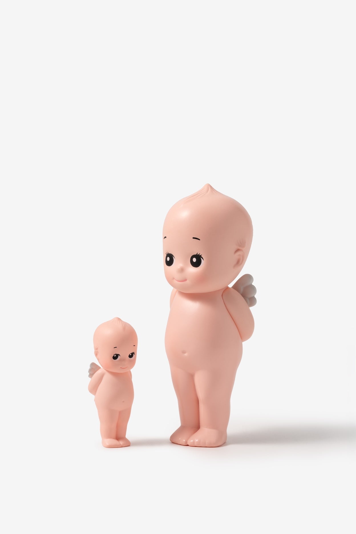 Two pink baby figurines on a white background