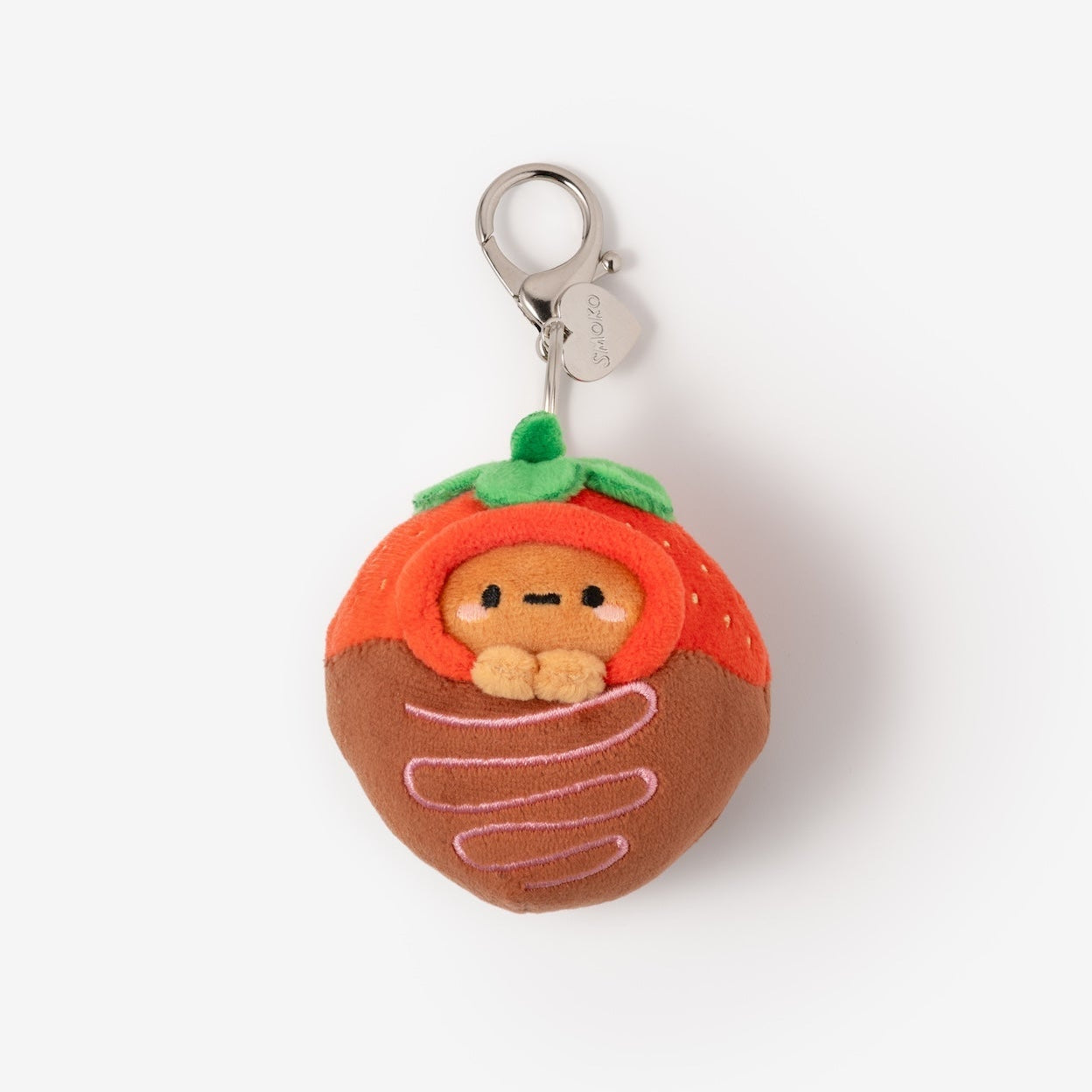 Plush keychain in the shape of a character inside a tomato on a white background