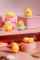 Yellow plush toys resembling lemons on pink shelves with cosmetic products.