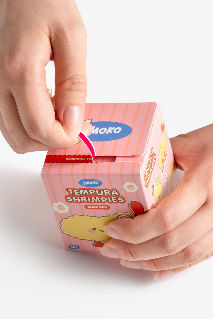 Person opening a pink box of Shoko Tempura Shrimpies on a white background