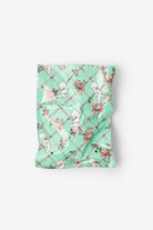 Mint green fabric with cupcake pattern on a white background