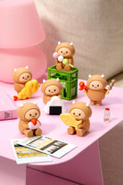 Set of small figurines on a pink surface with a blurred background