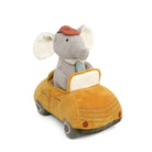 Plush toy elephant driving a yellow car on a white background