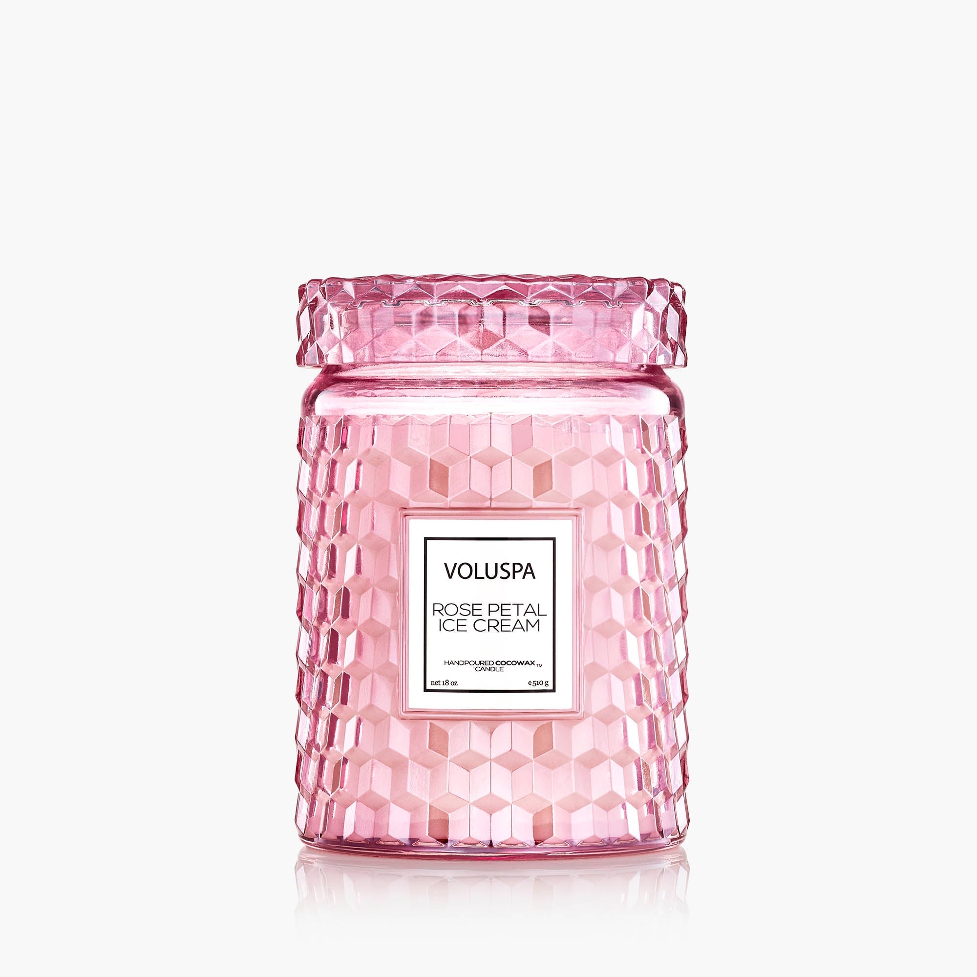 Pink Voluspa candle with textured glass and white label on a white background