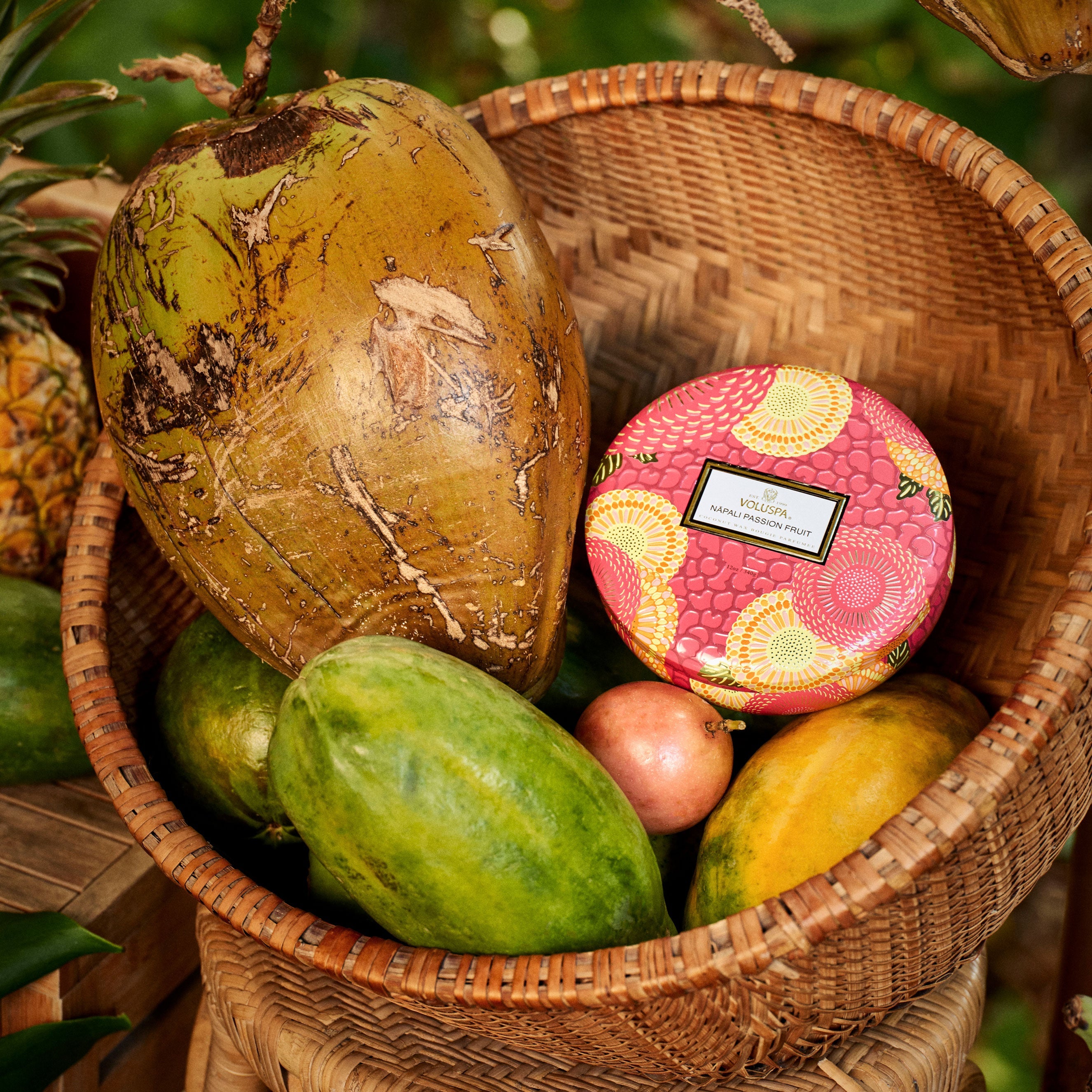 Basket with tropical fruits and a pink decorative item