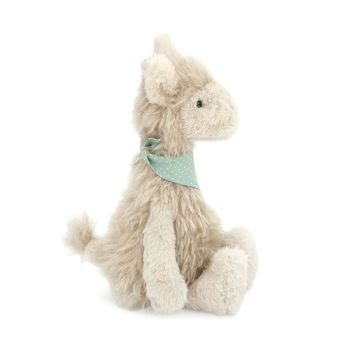 Stuffed beige donkey toy with polka-dot green bandana, seated.
