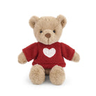 Plush teddy bear wearing a red sweater with a heart on a white background