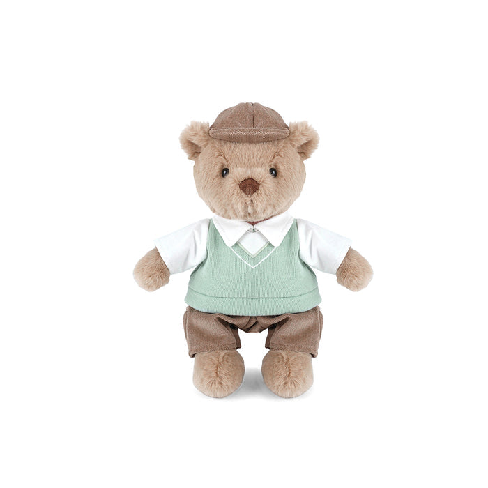 Stuffed teddy bear wearing a suit and hat on a white background