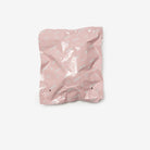 Pink crumpled paper bag on a white background