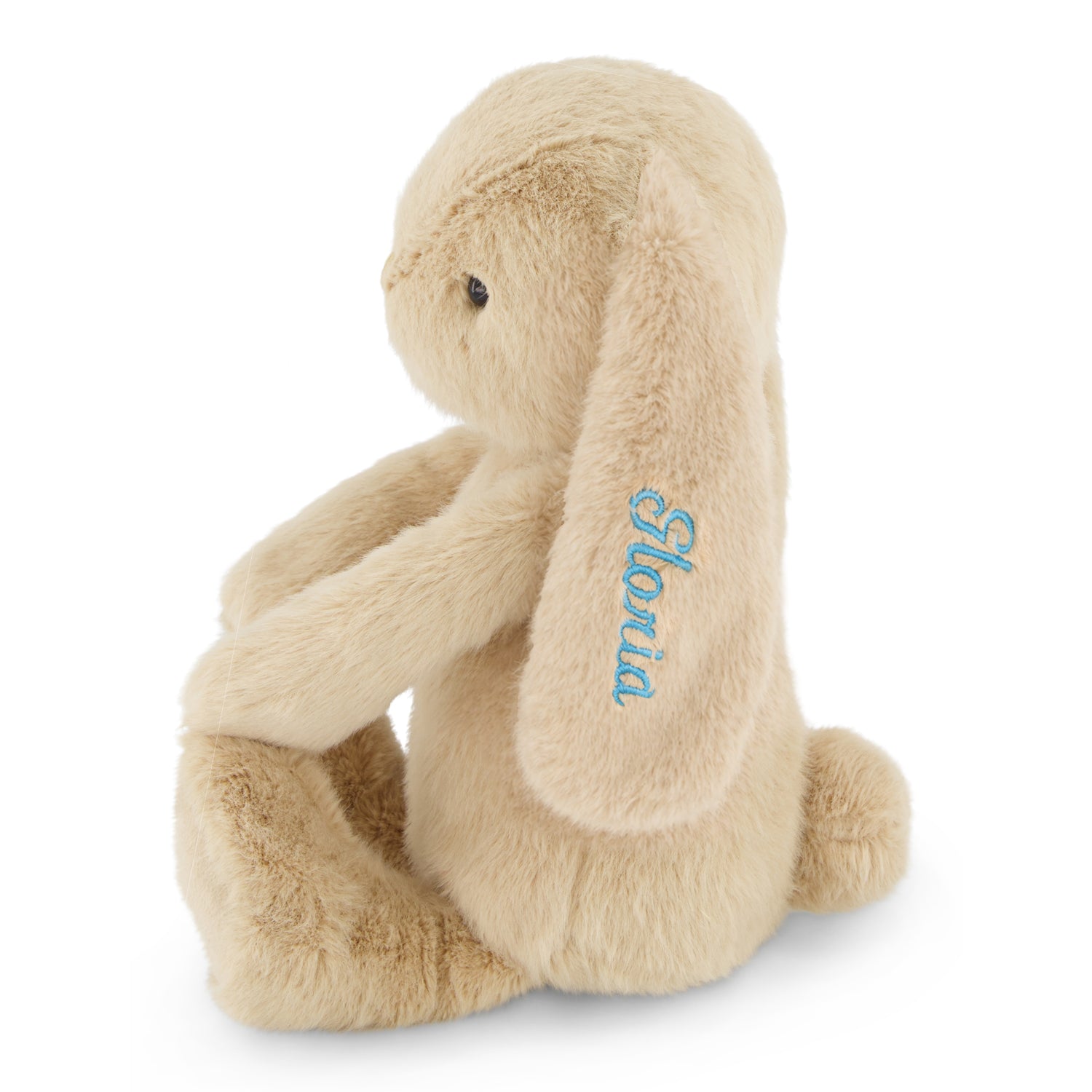 Beige plush bunny with blue embroidered name "Slovia" on ear, sitting side view, soft textured fur, 12-inch stuffed animal