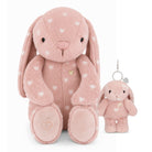 A pink plush bunny toy with white heart spots, shown alongside a smaller matching plush keychain with a silver clasp on a white background.