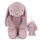 A soft plush bunny toy in dusty pink, shown seated next to a smaller matching plush keychain with a silver metal clip, on a clean white background.