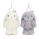 Two plush bunny keychains side by side on a white background, one cream white and one light gray, both with small gold heart charms and silver metal key rings.