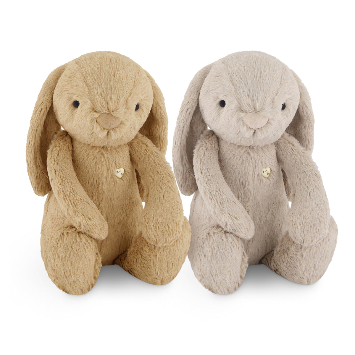 Two plush bunny toys side by side on a white background, one in tan and one in light gray, each with long floppy ears, black bead eyes, a stitched smile, and a small gold heart on the chest.