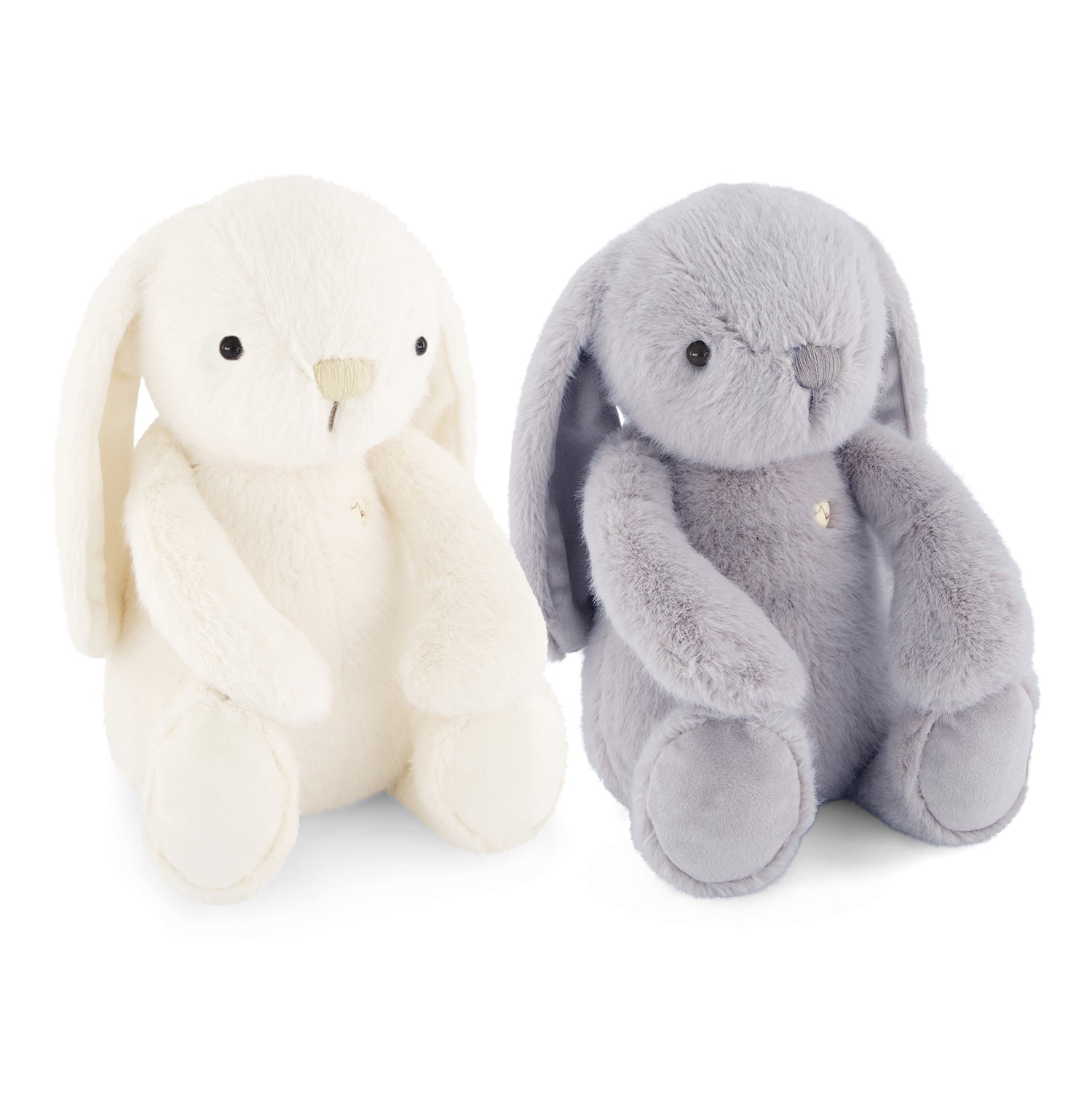Two plush bunny toys on a white background, one cream white and one light gray, both with long floppy ears, black bead eyes, and small gold-tone bell accents.