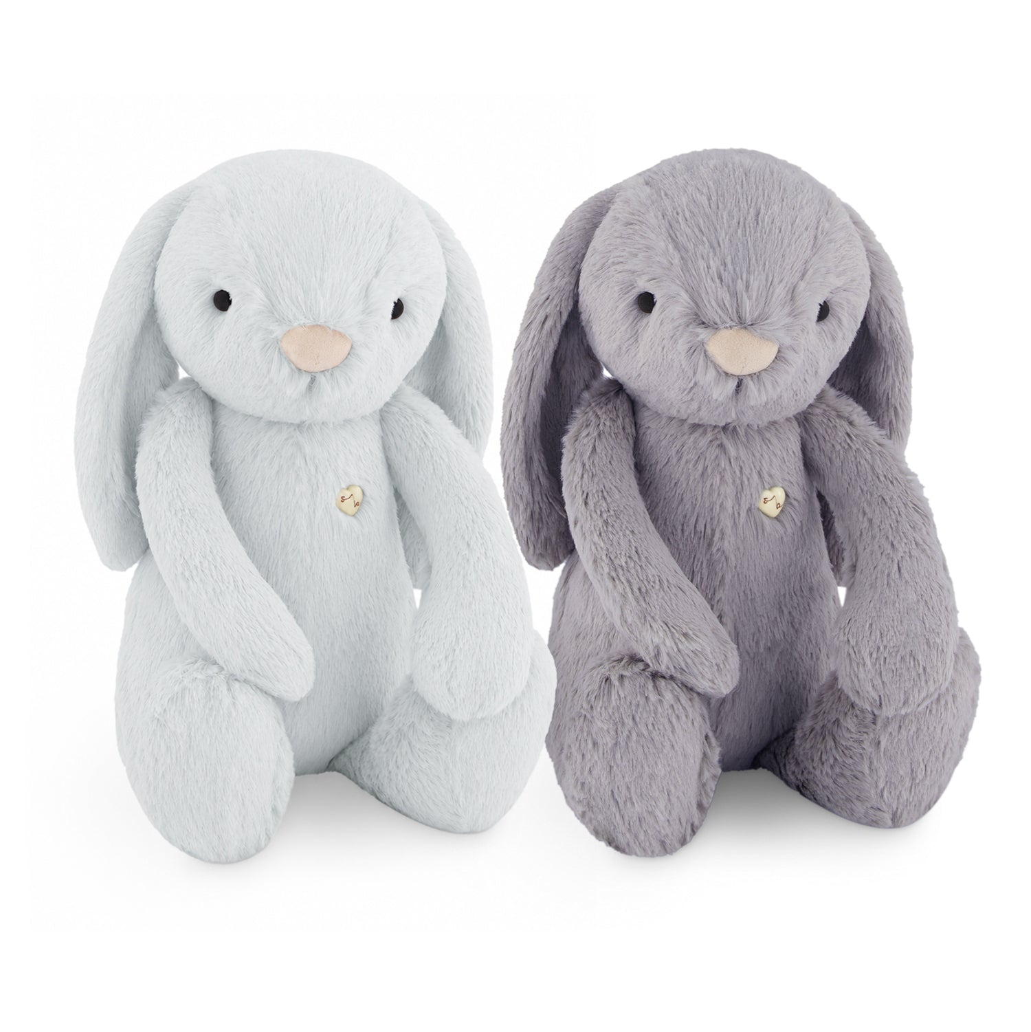 Two plush bunny toys on a white background, one in very light icy blue and one in medium gray, both with pale beige noses and small gold heart-shaped buttons.