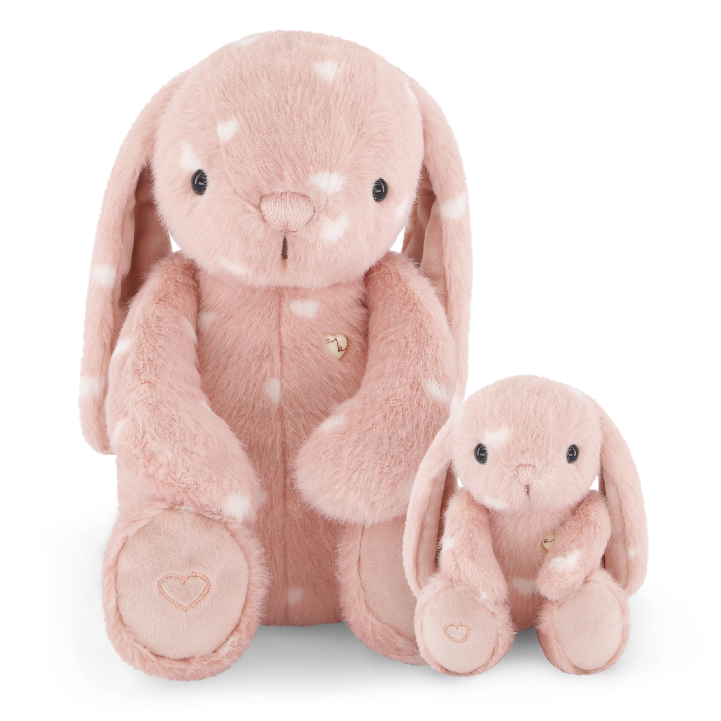 Two pink stuffed bunny rabbits with white hearts.