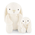Two white stuffed bunny toys, one larger than the other, sitting next to each other.