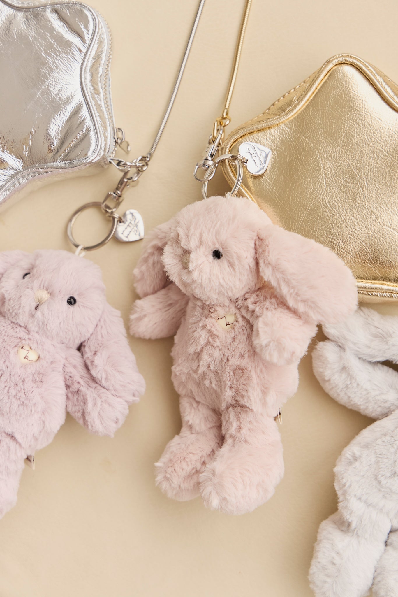 Assorted plush bunny keychains with metallic heart-shaped pouches.
