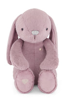 Pink plush bunny toy with heart details on a white background