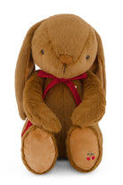 Brown plush bunny with a red bow tie on a white background