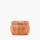 Candle with orange and white pattern on a white background