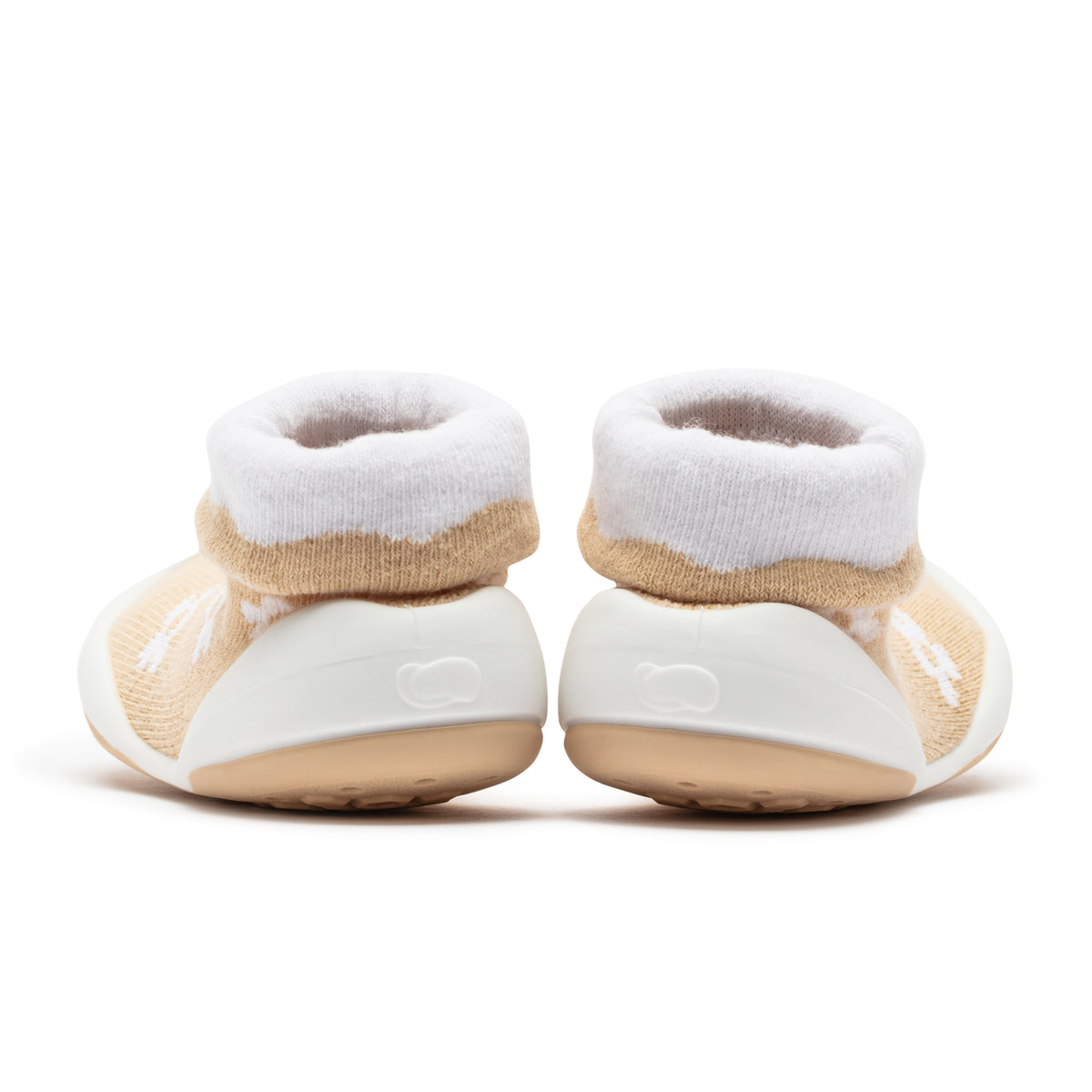 Two baby shoes with white and beige socks.