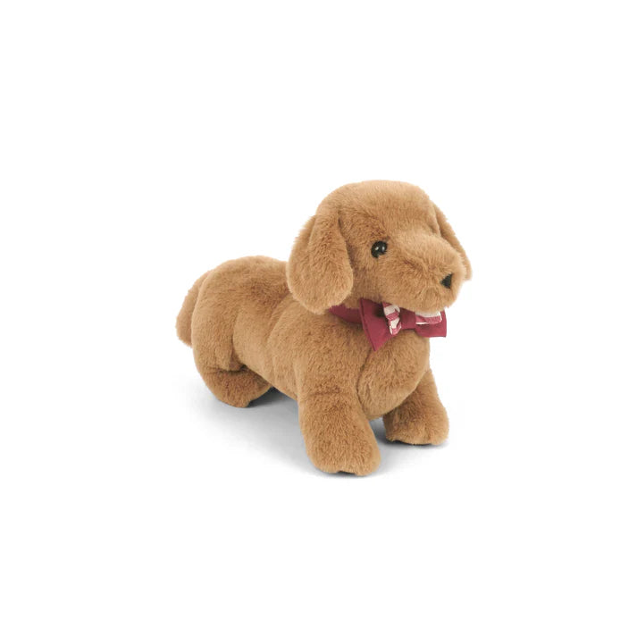 Plush toy dog with a red bow tie on a white background