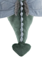 Close-up of a green dinosaur toy with a gray cape and fur details on a white background