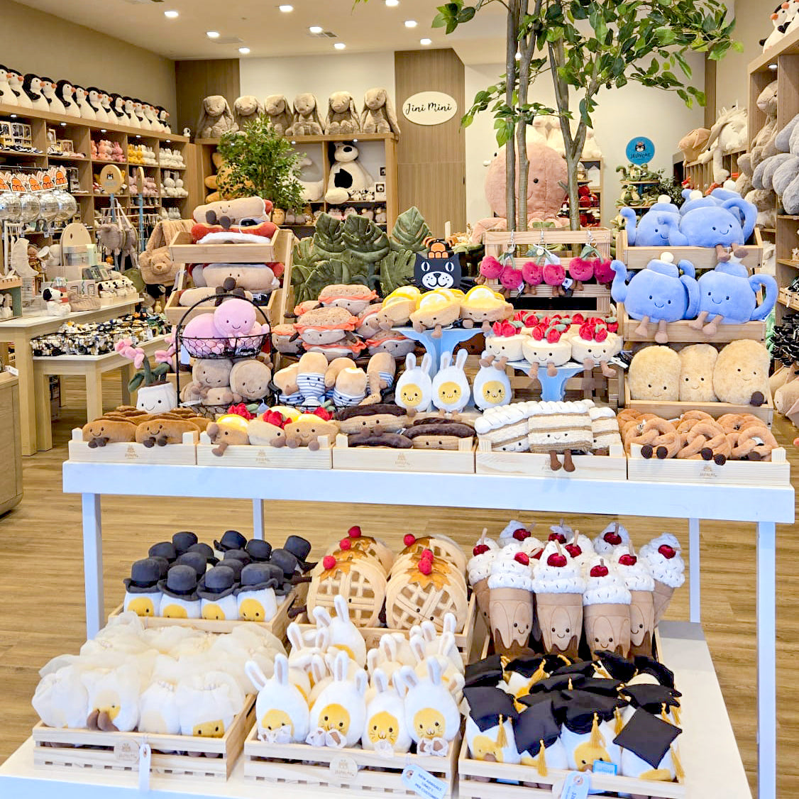 Display of various plush toys in a store setting with shelves and decor.
