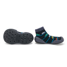 Two children's sock-shoe hybrids, one lying sole-up and the other standing. The footwear features black sock uppers with car patterns and gray soles.
