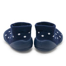 Pair of navy blue baby shoes with white polka dots on a white background