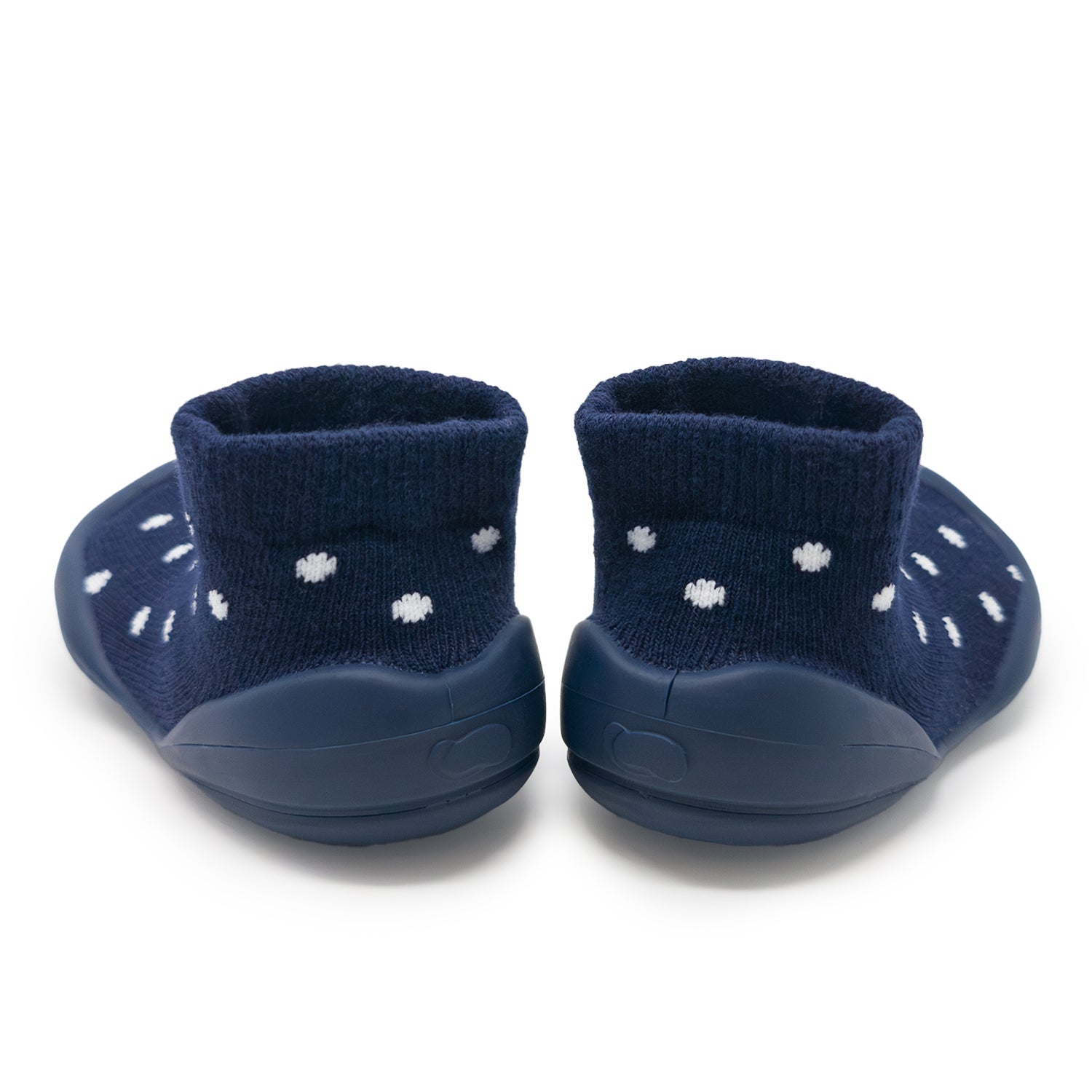 Pair of navy blue baby shoes with white polka dots on a white background