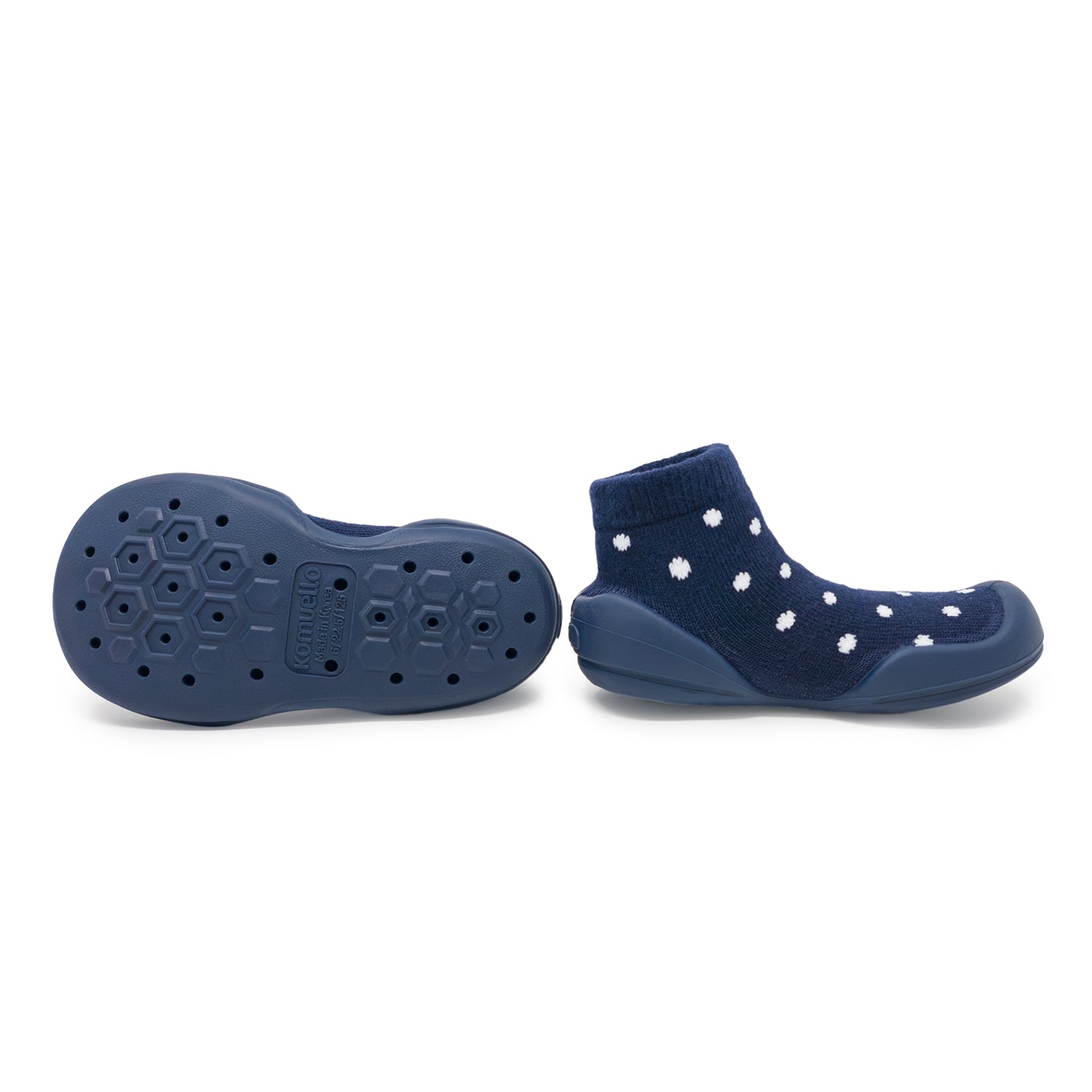 Navy blue socks with white polka dots and textured sole on a white background