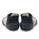 Pair of navy baby shoes with beige soles on a white background