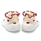 Pair of baby shoes with red hearts and ruffled edges on a white background
