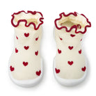 Pair of baby shoes with red heart patterns on a white background