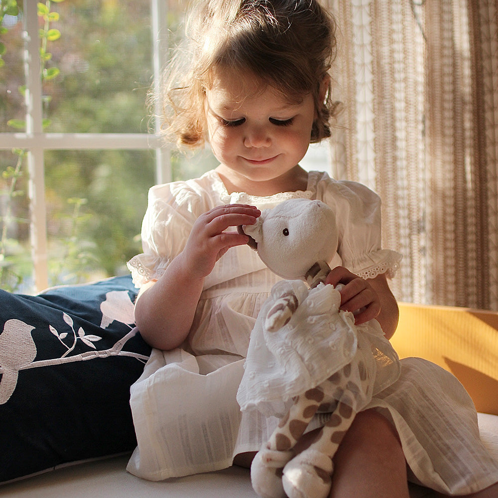 Child holding a stuffed animal in a cozy indoor setting