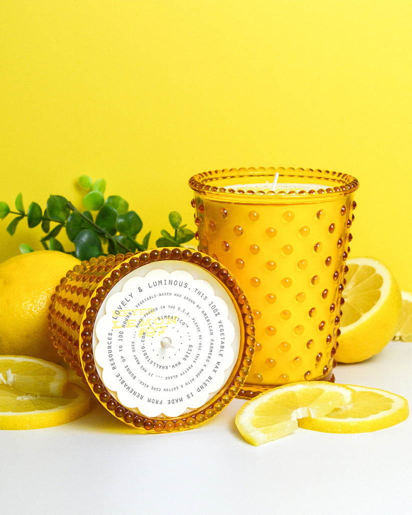 Decorative candle with a circular label on a yellow background with lemons