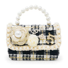 Decorative handbag with pearls and floral details on a white background