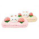 Two fluffy headbands, one pink and one yellow, each with a white bunny and a strawberry accent, against a white background.