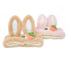 Two plush headbands, one brown and one pink, with bunny ears and strawberry accents.