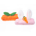 Two plush headbands; one orange with leaves, one pink with bunny ears and a carrot.