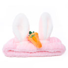 Pink and white plush headband with rabbit ears and carrot decoration.