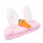 Pink and white furry bunny ear headband with an orange carrot applique.