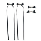 Four black ribbon bow clips, two with long streamers and two smaller, featuring silver alligator clips.